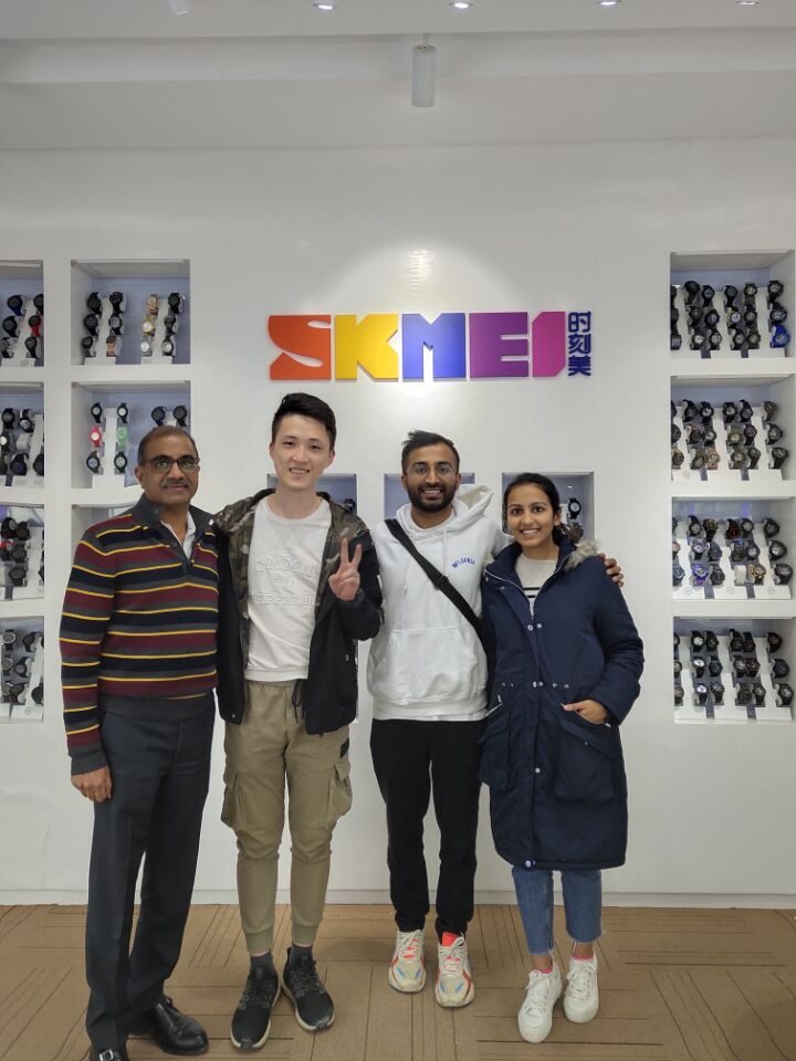 Overseas buyer group with SKMEI representatives at the showroom logo wall, December 2019