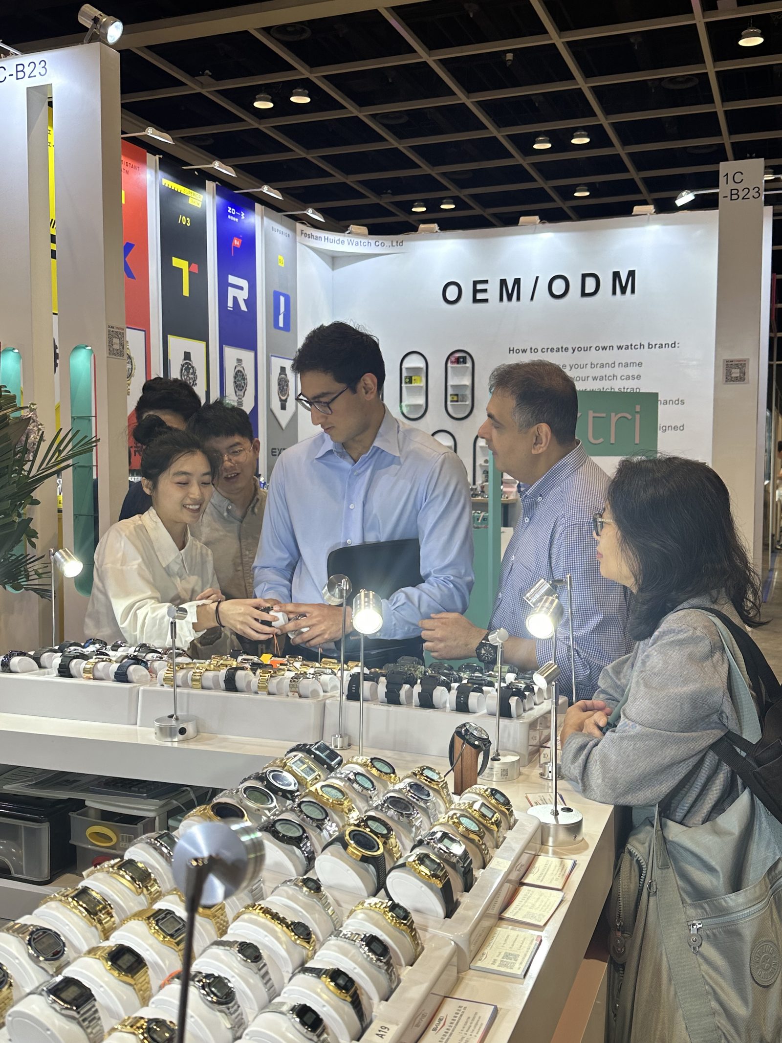 Buyers examining watches with the SKMEI team at the 2024 Hong Kong booth counter