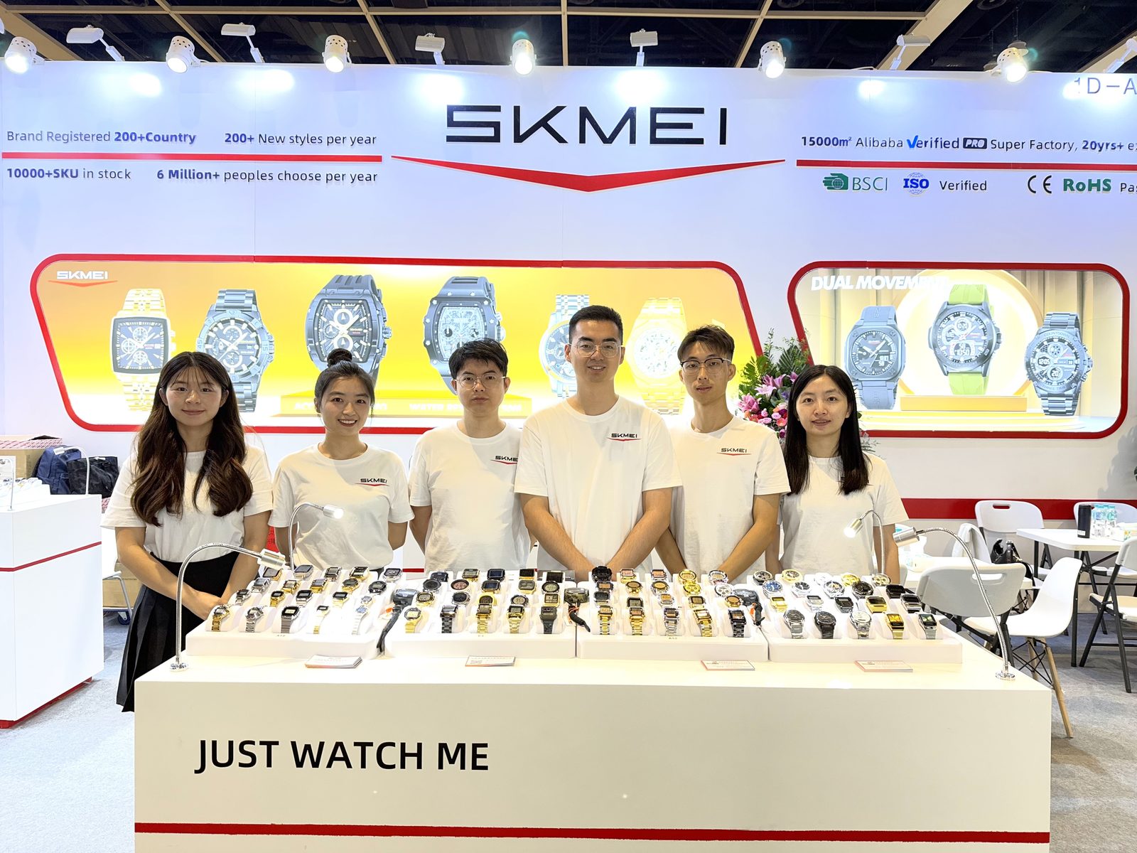 SKMEI team in front of the factory fact wall at the 2025 Hong Kong watch trade show booth