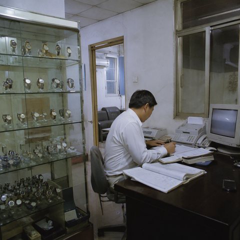 Scene illustration of an early trade office with a watch display cabinet